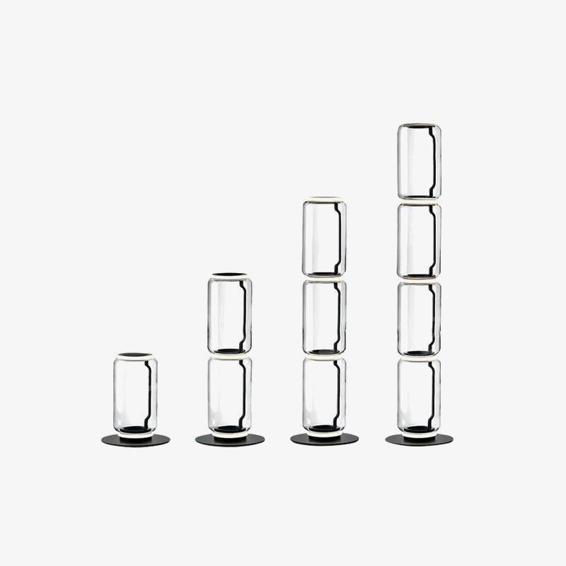 Four heights of the Clérachic glass floor lamp lined up on white, from one cylinder to four, each on a round black base.