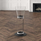 Close view of the cone shade and clear glass cylinder of this Clérachic floor lamp on a herringbone floor, with a white ring between them.