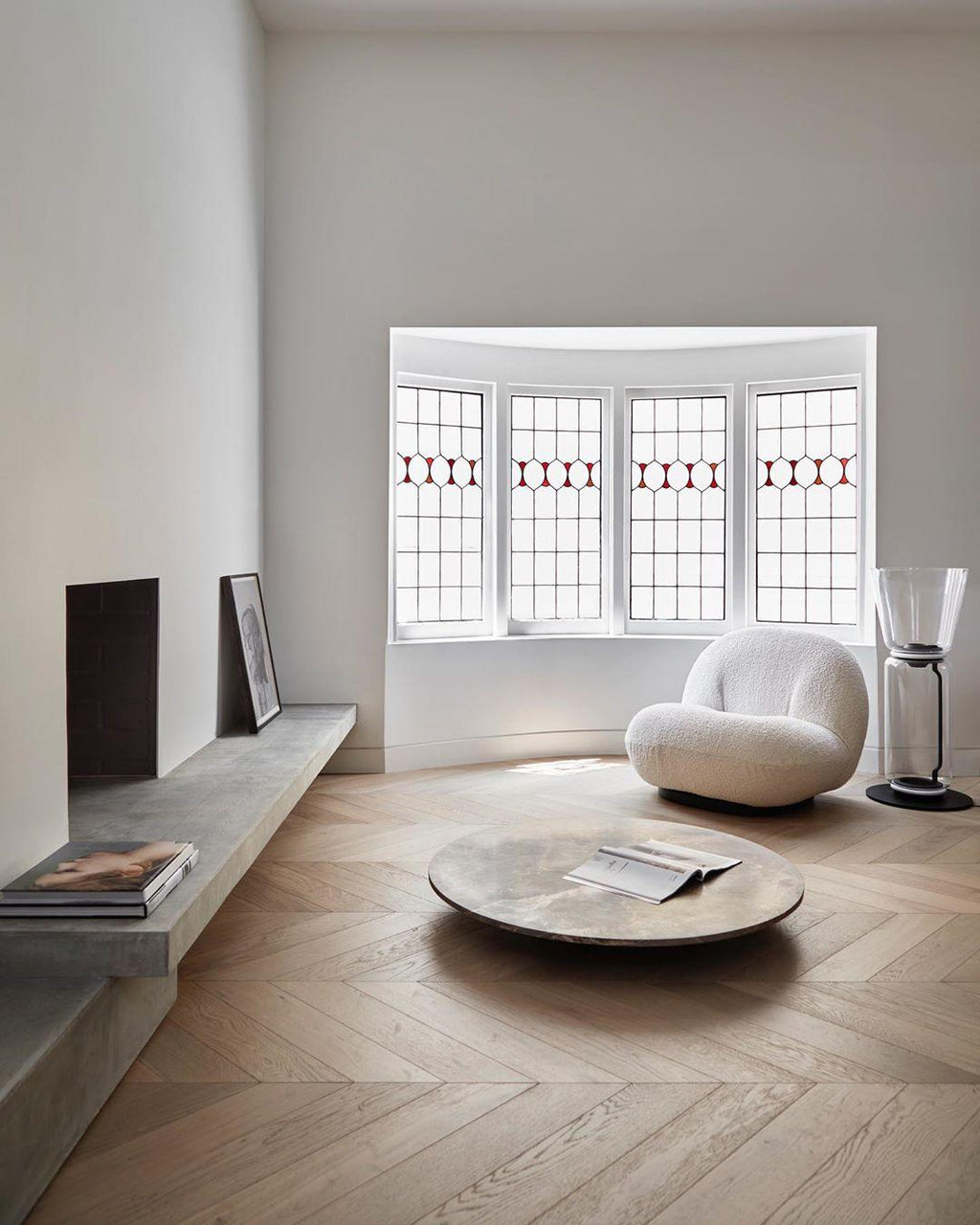Small Clérachic cone-shade glass floor lamp in a bay-window room, beside a cream armchair, a low round table and a wooden floor.