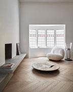 Small Clérachic cone-shade glass floor lamp in a bay-window room, beside a cream armchair, a low round table and a wooden floor.