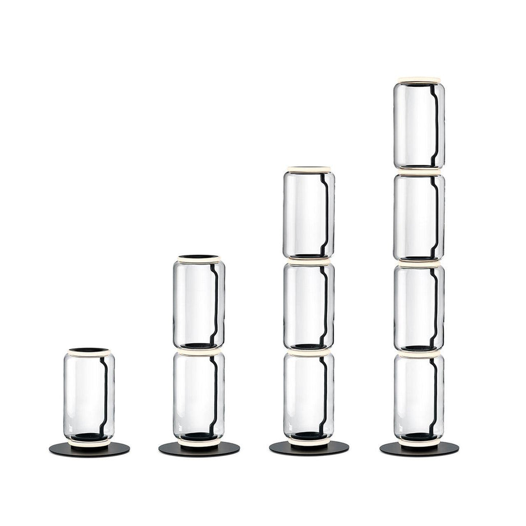 Four heights of the Clérachic glass floor lamp in a row on white, each a stack of clear cylinders on a black base.