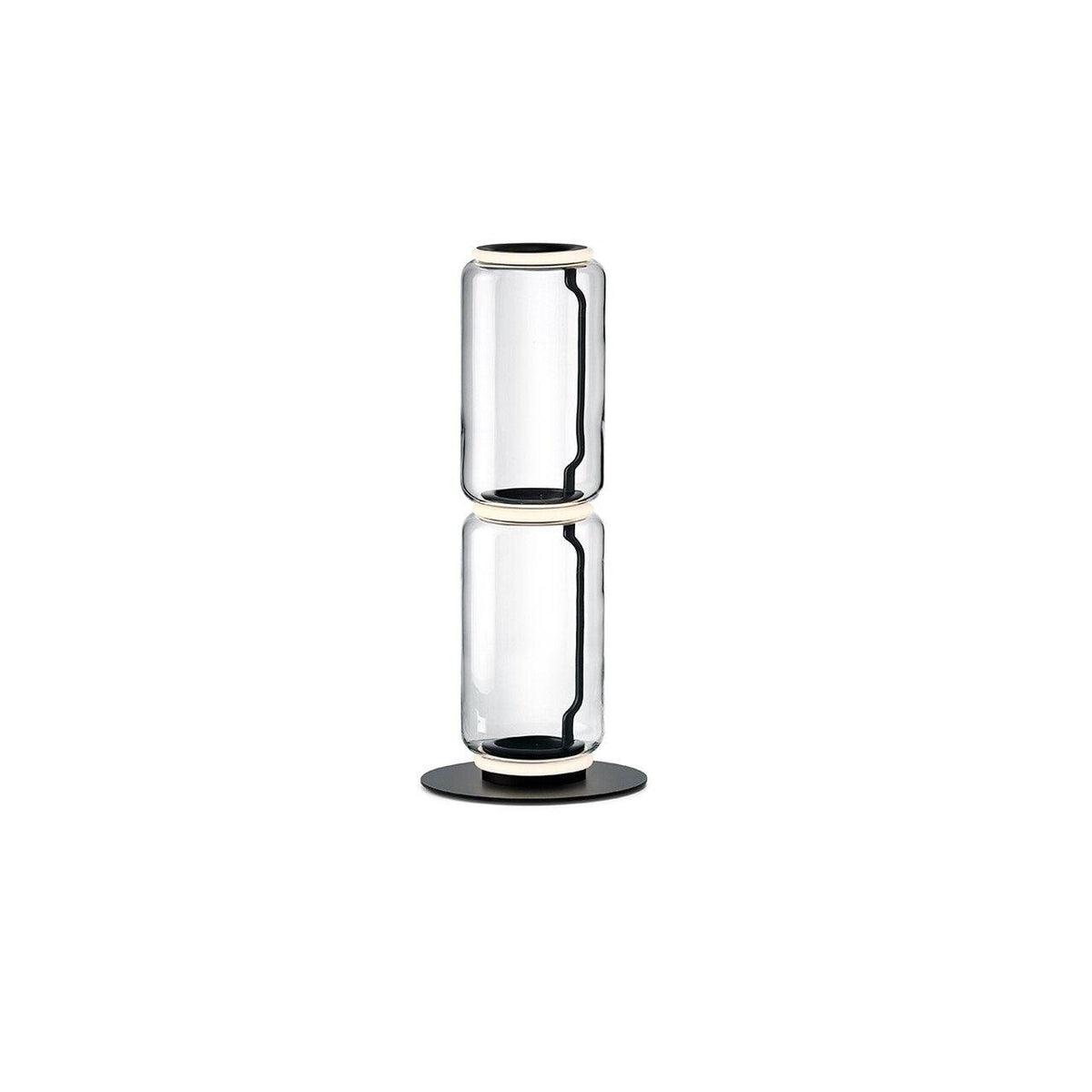 Clérachic glass lamp with two stacked clear cylinders and a ring of light at the top, on a round black base against white.