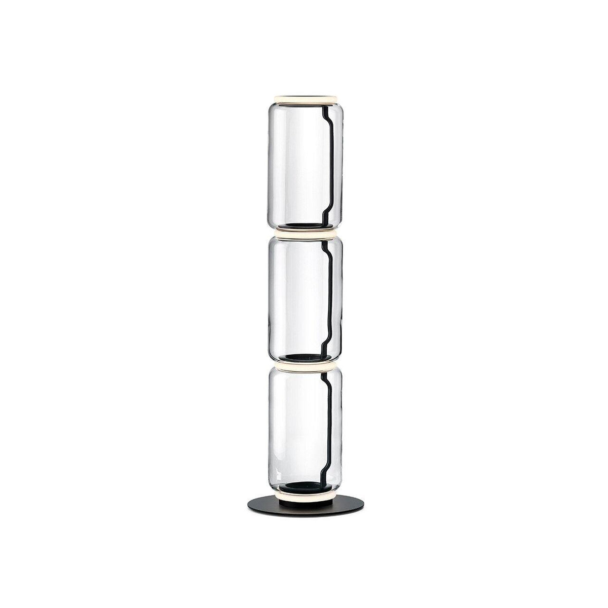 Clérachic glass floor lamp with three stacked clear cylinders and a ring at the top, on a black round base against white.