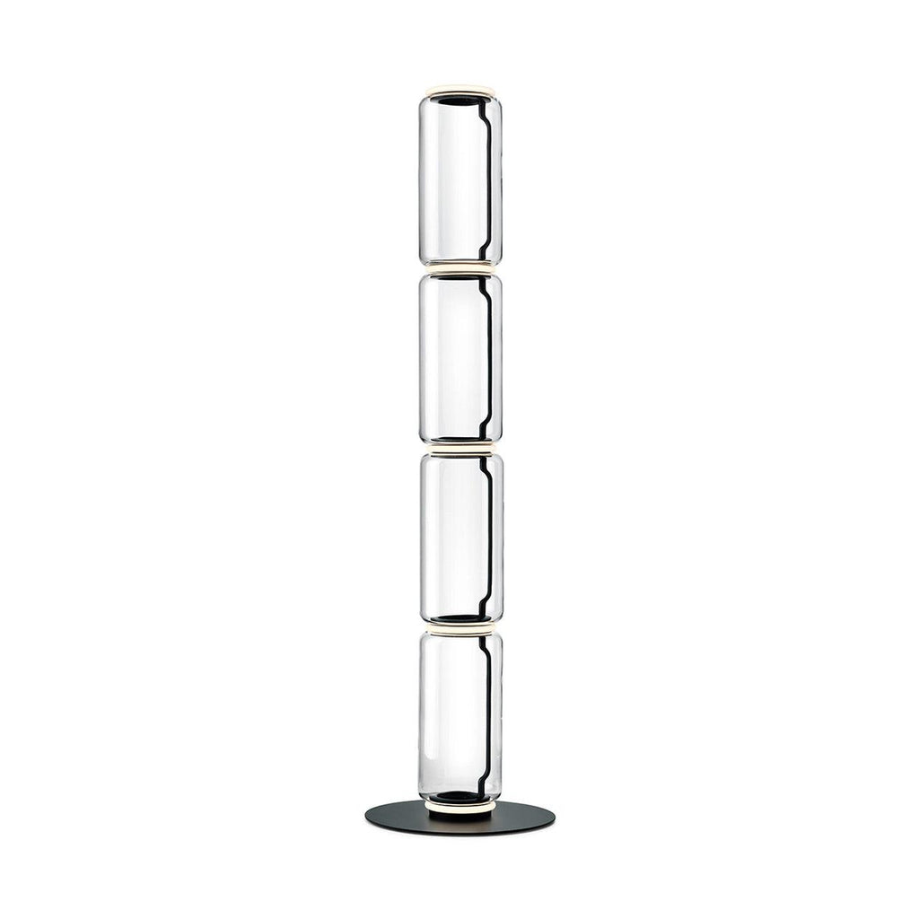 Clérachic glass floor lamp with four slim clear cylinders stacked on a round black base, on a plain white backdrop.