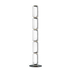Tall Clérachic glass floor lamp made of five narrow clear cylinders, stacked on a round black base against white.