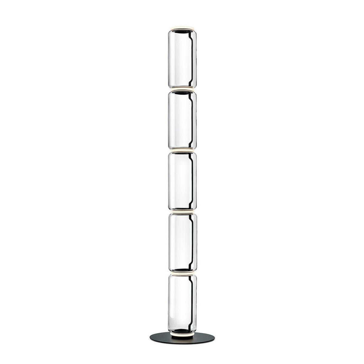 Tall Clérachic glass floor lamp made of five narrow clear cylinders, stacked on a round black base against white.