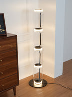 Lit Clérachic glass floor lamp at the edge of a walnut chest, warm light ringing each joint and shining on the base.