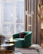 Clérachic glass floor lamp with a bowl shade by a floor-to-ceiling window, near a green velvet armchair and drapes.