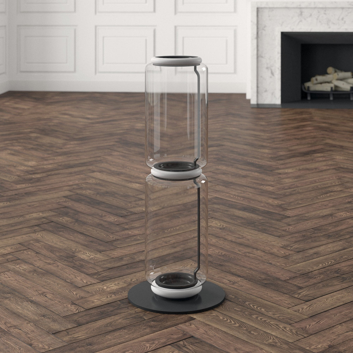 Clérachic glass floor lamp with two clear cylinders and a white ring, on a herringbone floor in front of a white stone fireplace.