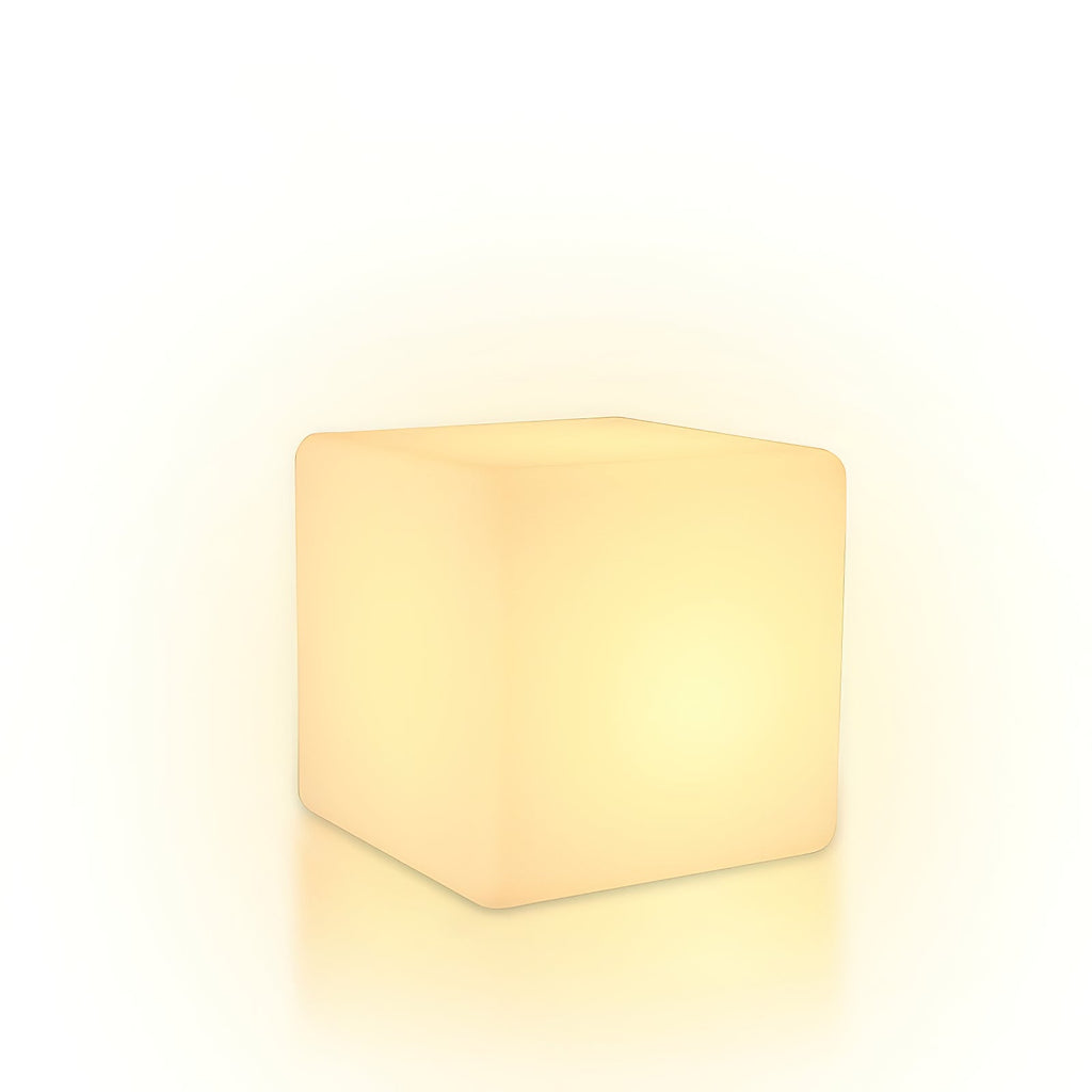 With a soft halo of warm light around it, this white Clérachic cube lamp stands on a white backdrop.