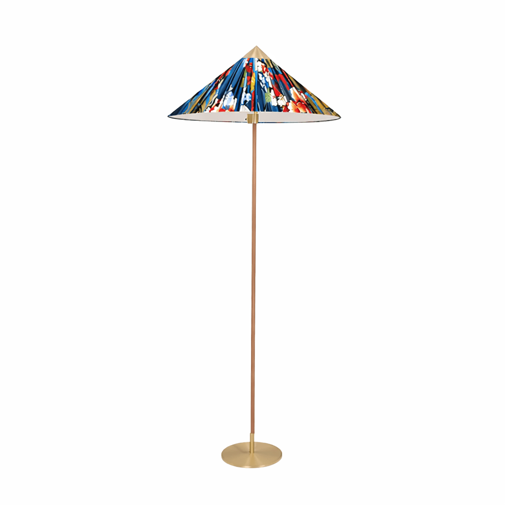 Pictured here, a Clérachic floor lamp with a blue and red printed shade and a slim stem on a round brass base, on a plain white backdrop.