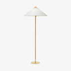 Shown here, a Clérachic floor lamp with a white fabric shade and a cane-wrapped stem, shown on a plain light backdrop, with a brass cap and foot.