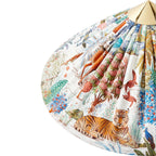 Close view of the printed shade on this Clérachic floor lamp, showing a tiger among painted trees and birds, with a brass cap.