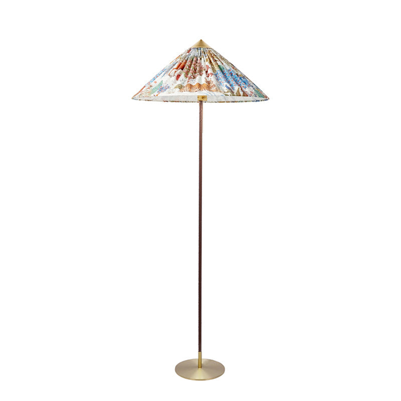 Shown here, a Clérachic floor lamp with a printed shade, a dark stem and a brass base, on a plain white backdrop.