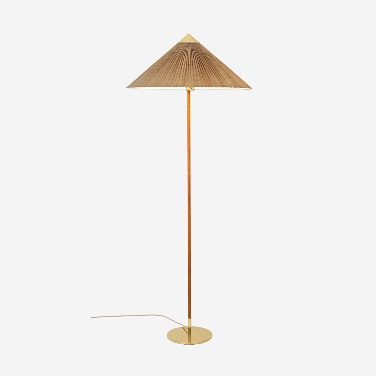 Clérachic floor lamp with a bamboo slat shade, a cane-wrapped stem and a brass base, on a pale backdrop with its cord trailing out.