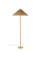 Pictured here, a Clérachic floor lamp with a bamboo slat shade and a cane-wrapped stem on a brass base, on a green backdrop, its cord trailing out.