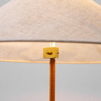 Close view of the brass fitting under the shade of this Clérachic floor lamp, where it meets the tan wrapped stem.