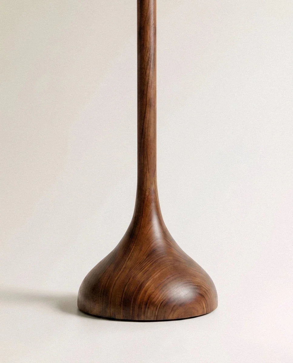 Clérachic floor lamp base, a smooth turned wooden foot with rich grain sweeping up into a slender stem.