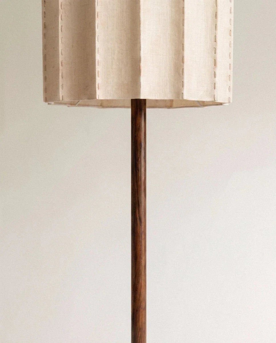 Underside of the Clérachic floor lamp shade showing its pleated fabric edge where the wooden stem meets the shade.