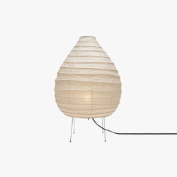 Clérachic teardrop paper lantern table lamp on a white studio backdrop, the bulb glowing warm through the belly of the ribbed shade.