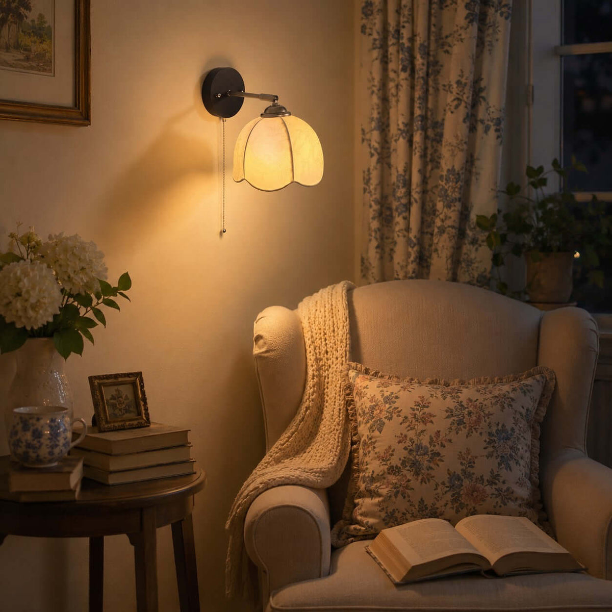 Clérachic wall light casting a warm glow over a floral armchair, an open book and a side table in a reading corner.