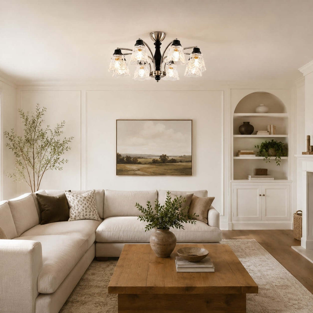 Clérachic glass-shade chandelier over a cream corner sofa and a wooden coffee table, with a built-in alcove shelf behind.