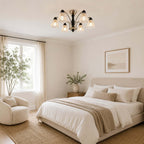 This Clérachic chandelier lights a bedroom with white linen bedding, a jute rug and a pale wood bedside table.