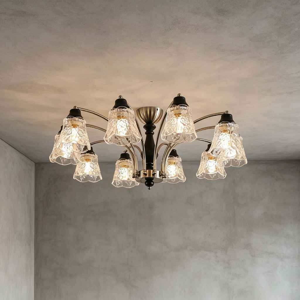 Lit Clérachic ten-light chandelier on a grey concrete-look ceiling, with all its floral glass shades glowing warm.