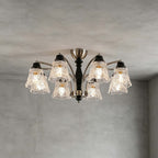Clérachic eight-light chandelier on a grey ceiling, its clear floral shades and black wooden column seen from slightly below.