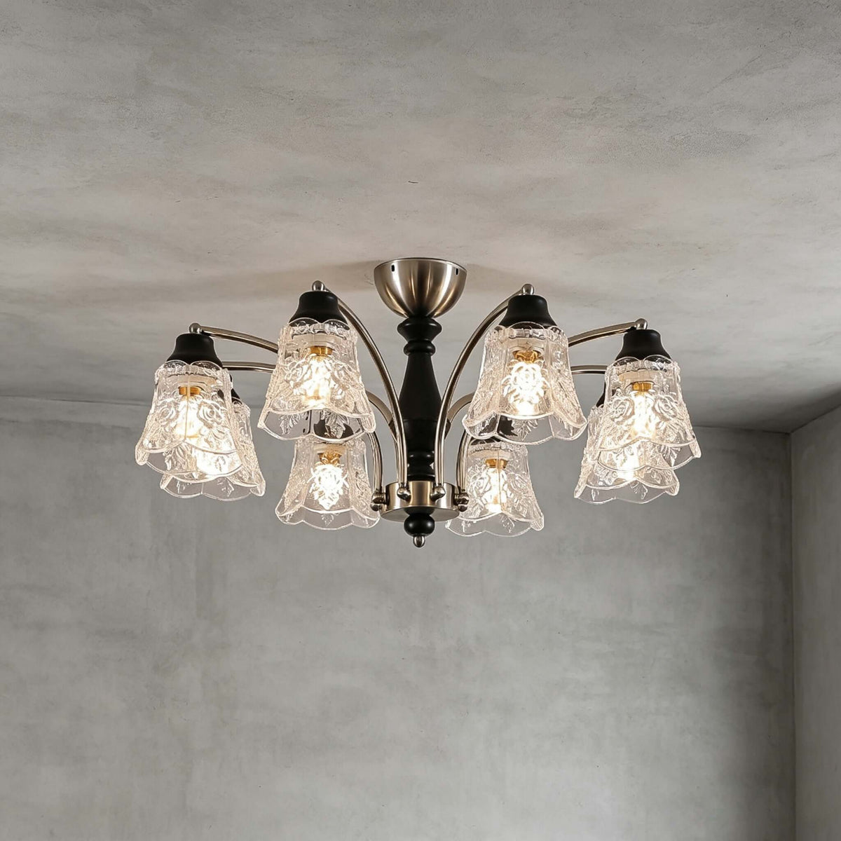 Clérachic eight-light chandelier on a grey ceiling, its clear floral shades and black wooden column seen from slightly below.