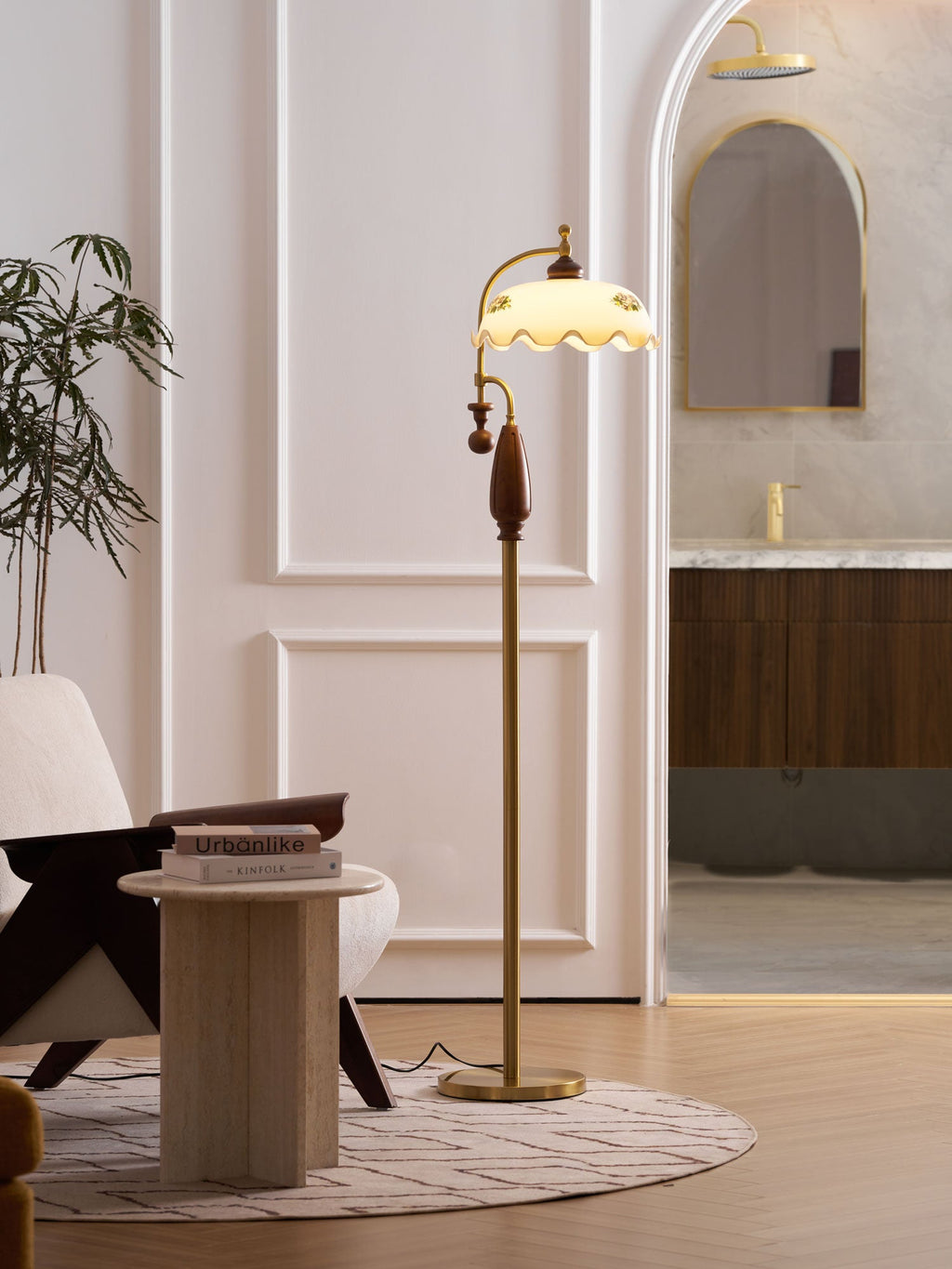 Tall view through an arched doorway, with the floor lamp lit beside a side table and an armchair; a Clérachic design.
