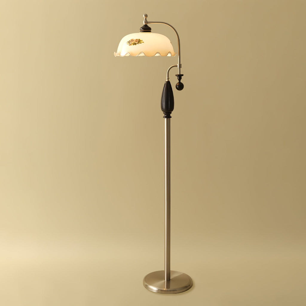 A black-wood and nickel-toned version of the floor lamp on a gold studio backdrop, with the frilled shade lit; from Clérachic.