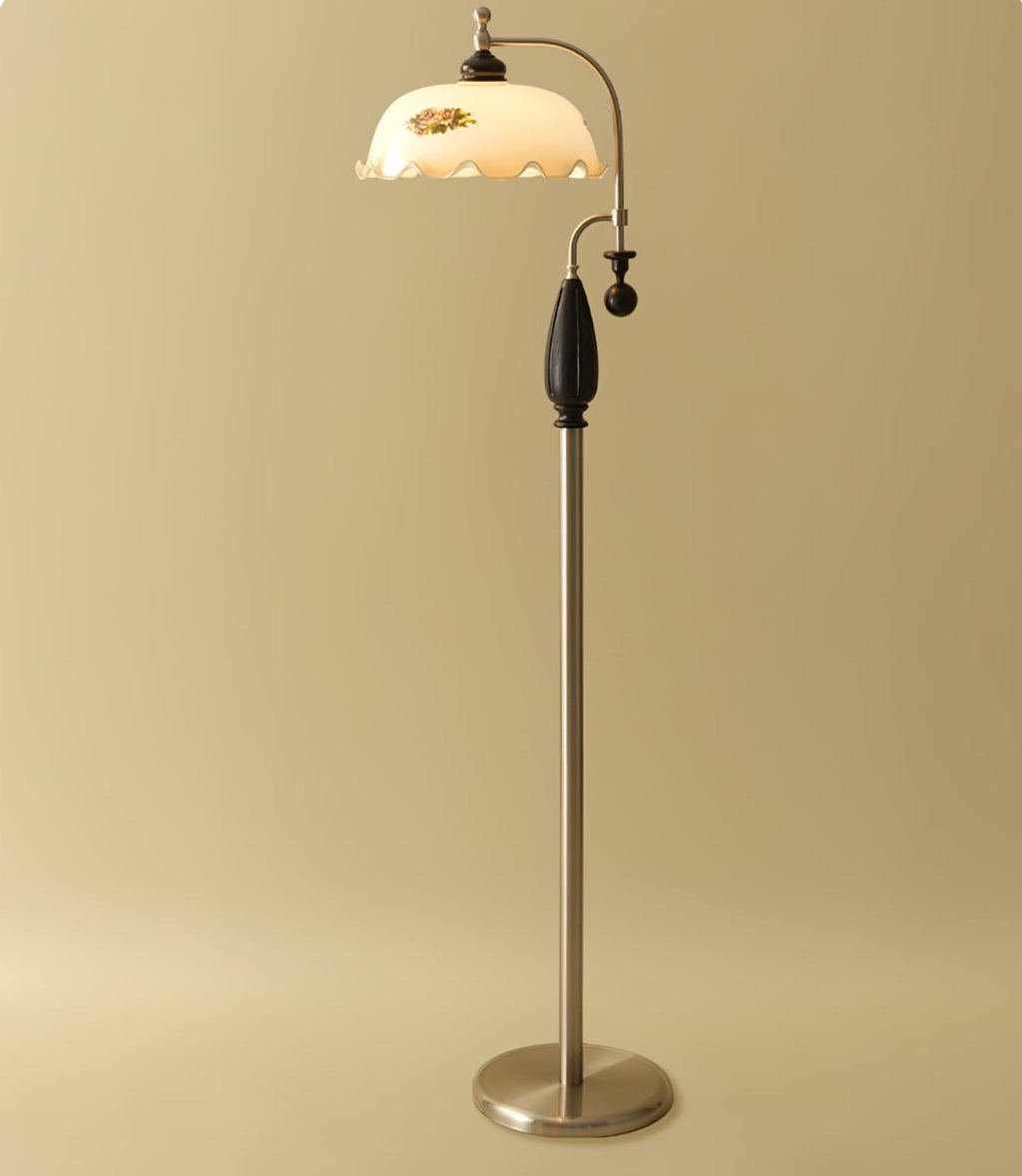 Nickel-toned version with a black wooden grip on a soft gold backdrop, shade lit and frilled; a Clérachic floor lamp.