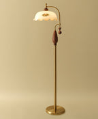 Brass and walnut version on a soft gold backdrop with a round brass base, shown for this Clérachic floor lamp.
