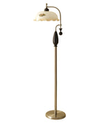 Nickel and black floor lamp on plain white, with a round nickel base and a frilled cream shade; from Clérachic.