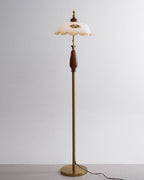 Straight-on studio view of the floral shade at the top of a slim brass stem, against light grey; a Clérachic floor lamp.