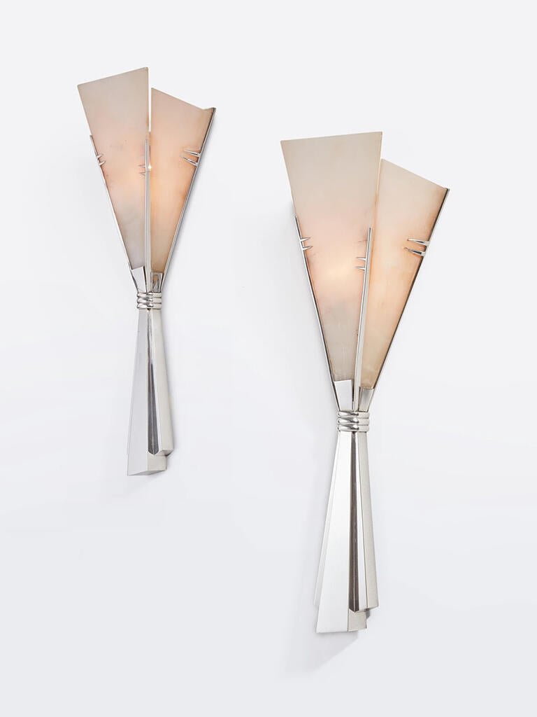 Two Clérachic Florent sconces angled on white, nickel stems catching the studio light.