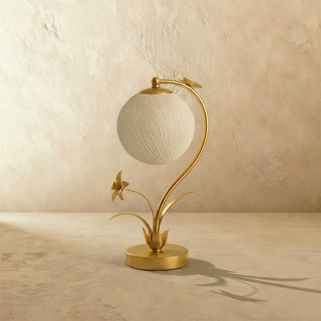 Clérachic gold table lamp switched off, a textured woven off-white sphere hanging from a curved stem with a metal flower.
