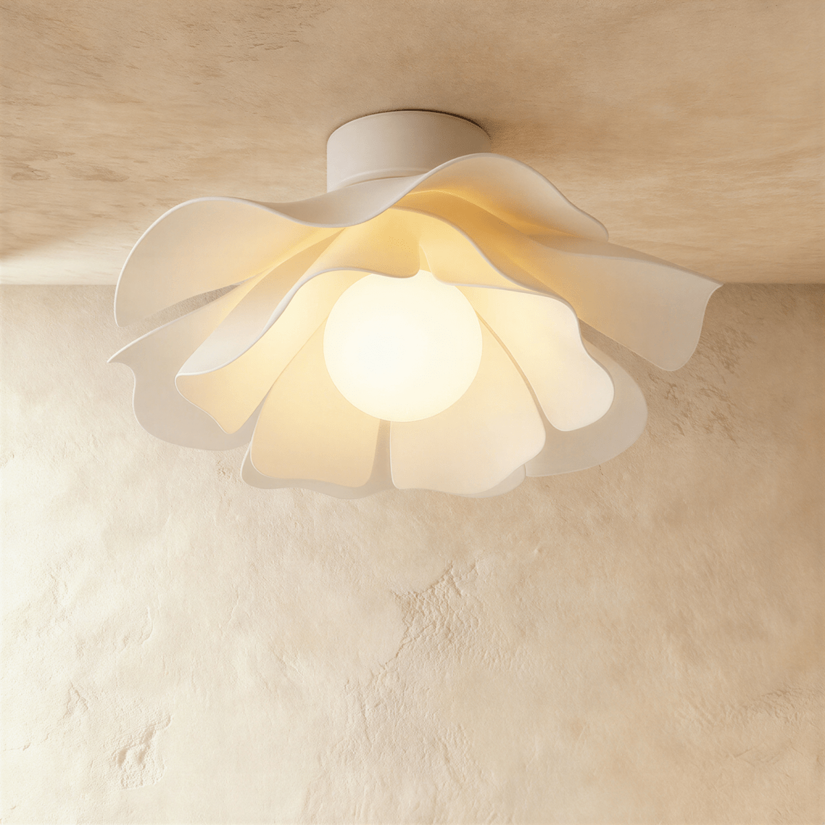 Clérachic white acrylic ceiling light with a wavy petal-like shade and a glowing round bulb, lit against a limewash ceiling.