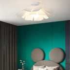 Clérachic white ceiling light with a frilled petal shade, lit above a teal feature wall and a round-headed upholstered bed.