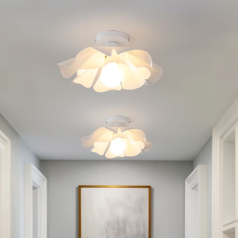 Clérachic pair of white petal-shade ceiling lights glowing warmly along a pale hallway with a gold-framed artwork at the end.