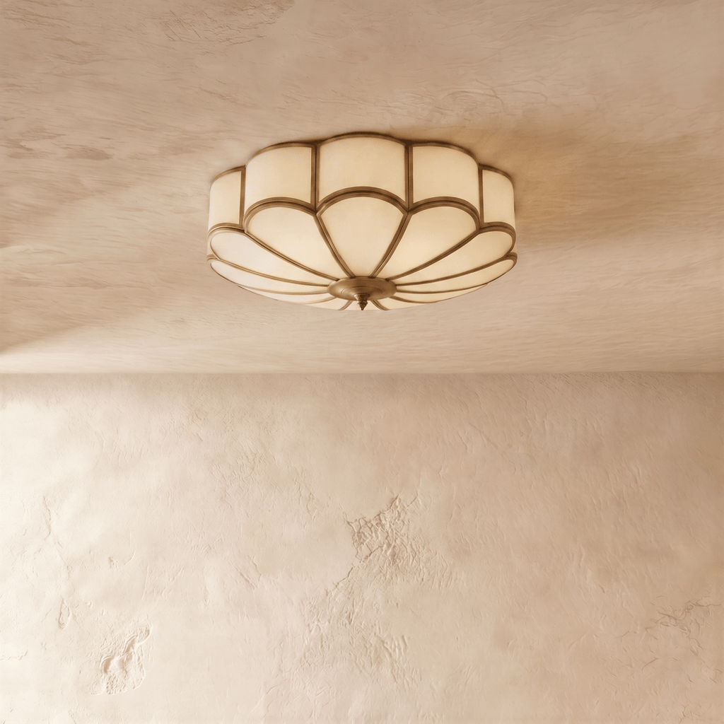 Clérachic scalloped flush ceiling light switched off, frosted glass panes set in slim brass-toned ribs on a plaster ceiling.