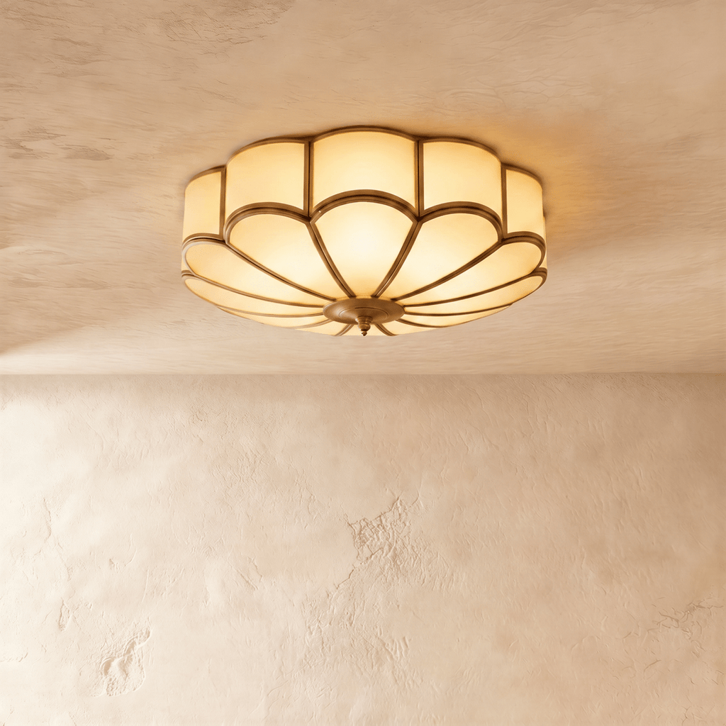 Clérachic larger scalloped flush ceiling light, lit warm, with frosted glass panels and thin brass-toned ribs on plaster.