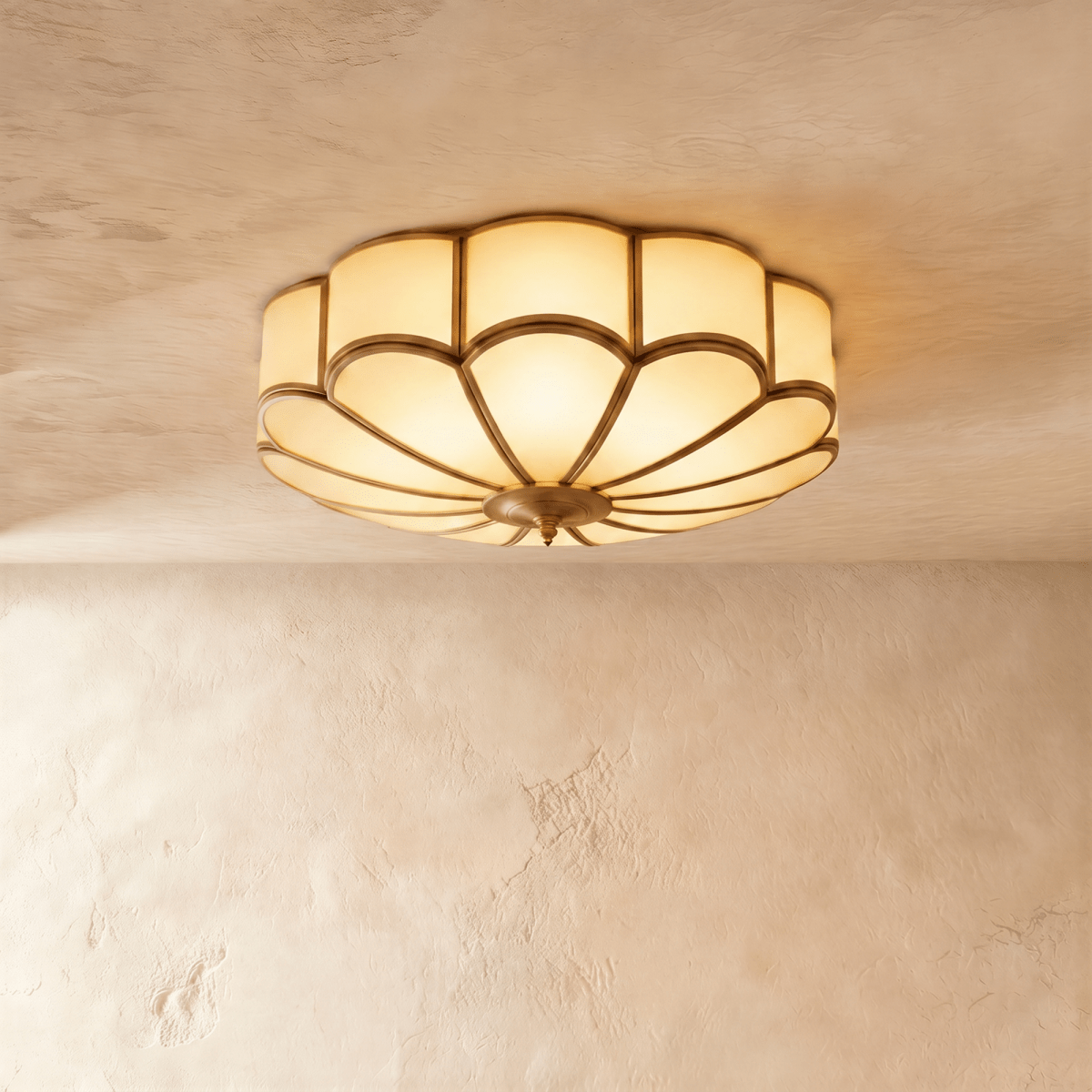 Clérachic wide scalloped flush ceiling light, lit warm, with frosted glass panels and a brass-toned centre boss.