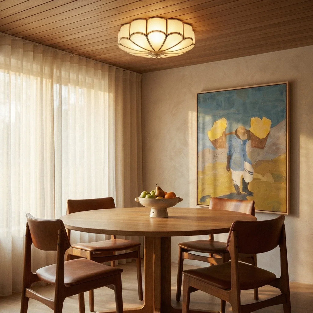 Clérachic scalloped flush ceiling light on a timber-clad dining room ceiling, above a round oak table and leather chairs.