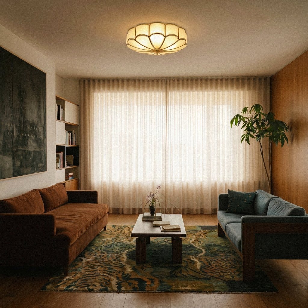 Clérachic scalloped flush ceiling light glowing in a living room with a rust sofa, sheer curtains and a patterned rug.