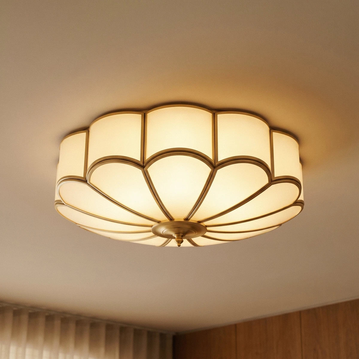 Clérachic scalloped flush ceiling light close up from below, lit warm with frosted glass and brass-toned ribs.