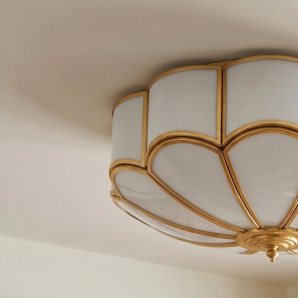 Clérachic scalloped flush ceiling light viewed from below, milk-white glass panels framed in polished brass-toned ribs.