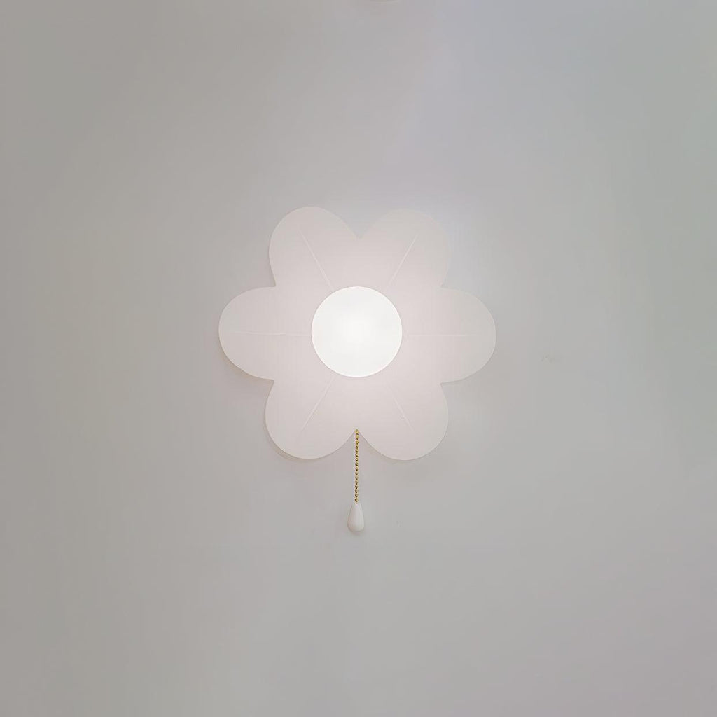 A Clérachic flower wall light with a soft pearly glow on a grey wall, its petals gently translucent and a white pull on the chain.