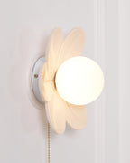 Side view of the Clérachic flower wall light, showing a round white wall plate behind the petals and the deep frosted globe.